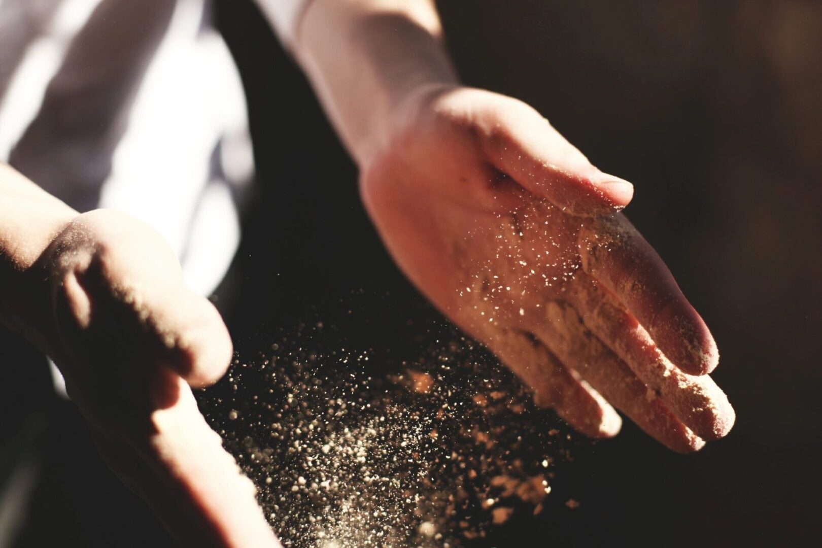 A person 's hands reaching for some sand