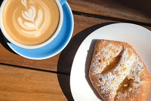 A plate of food and a cup of coffee on a table.