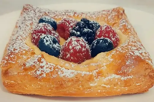 A pastry with berries on top of it.